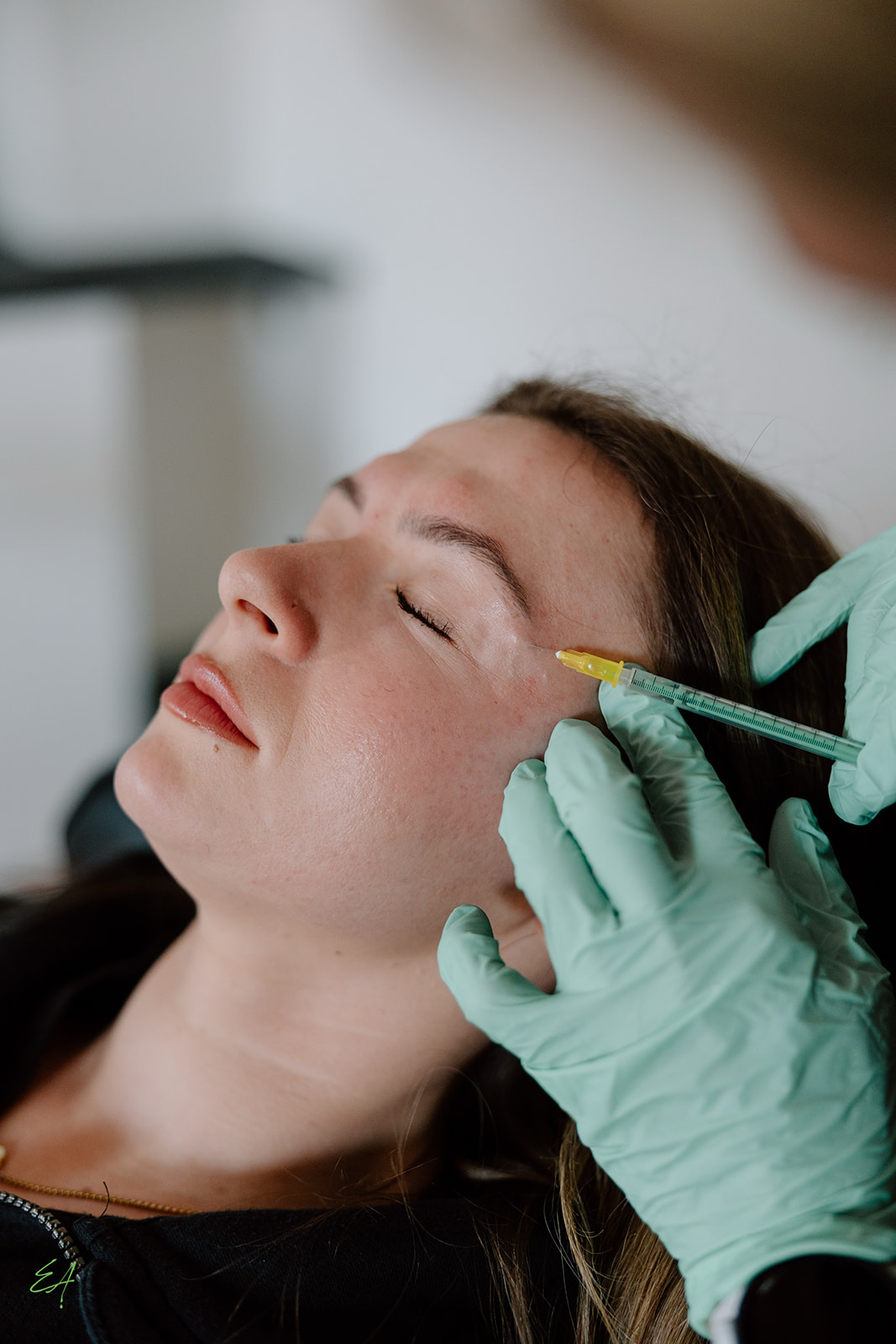 A client closes her eyes while Kasia injects neurotoxin units.